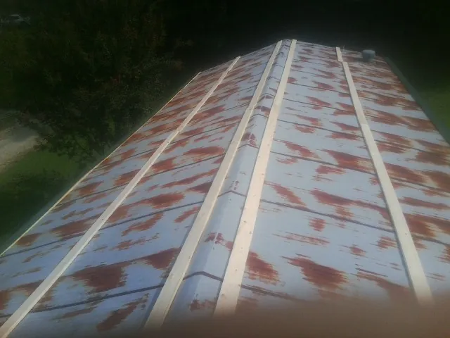 Rusted metal roof panels with new wood purlins before replacement — Storm Damage Roof Repair in Adger by Roofing Brothers