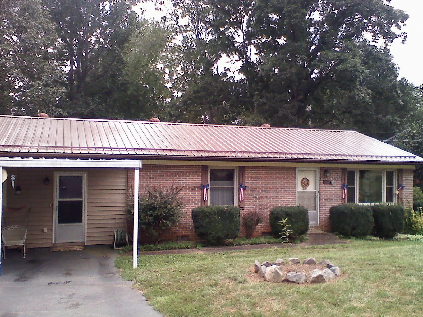 Bronze metal roof and carport on a brick ranch home — Roof Repair work by our crew in Adger
